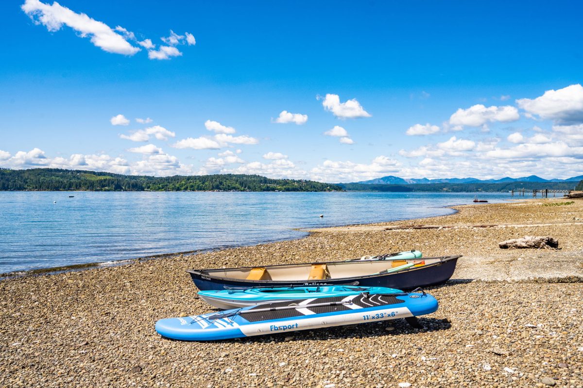 Kayaks and paddleboards on a Hood Canal beach